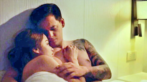 Tattooed Asian hunk cuddles topless Asian beauty intimately in bed