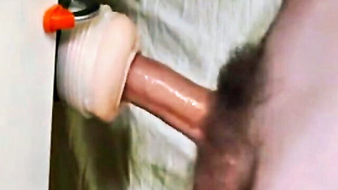 Man grimacing in intense climax using Fleshlight masturbator close-up