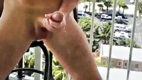 Young amateur guy stroking his hard cock with precum on outdoor balcony