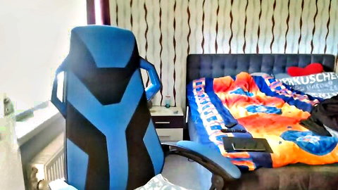 Empty German webcam bedroom setup with blue gaming chair and orange bed ready for solo pussy play