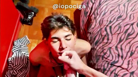 Gay twink with collar sucks on thick male fingers lying nude on pink zebra bed