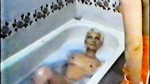 Mature blonde with small tits nude in bubbly bathtub vintage scene