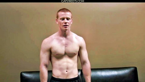 Muscular young ginger hunk shirtless flexing ripped abs in shorts