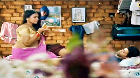 Curvy brunette Indian MILF in pink saree with big tits leaning over shirtless man on bed