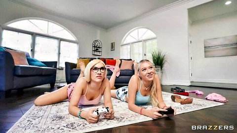 Two blondes in skimpy lingerie lying on floor playing video games with feet up teasing asses