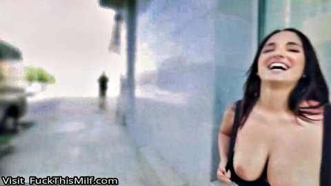 Claudia Bavel smiling in low-cut black dress with massive cleavage outdoors