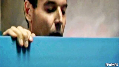 Intense man gripping blue ledge peeking down voyeuristically