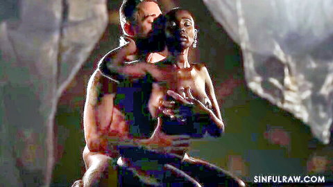 Muscular man passionately embraces topless energetic ebony beauty