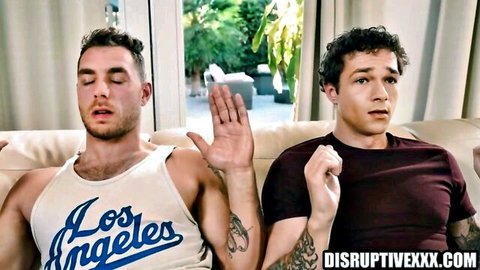 Two fit young men lounging shirtless in casual gay threesome setup