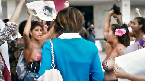 Topless women protesters flashing painted tits and bare breasts in crowded street rally
