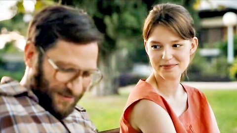 Ania Bukstein in orange dress chatting with co-star outdoors, sexy celeb scene