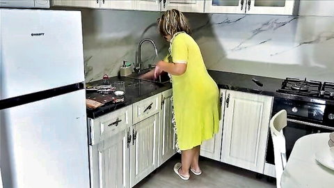 Yohanpok in tight yellow dress bending over kitchen sink, teasing stepson