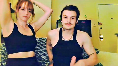 Strawberryespresso in black tank top with male partner, teasing Chaturbate cam show