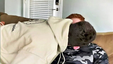 Redhead in camo receives oral from feminine hooded man