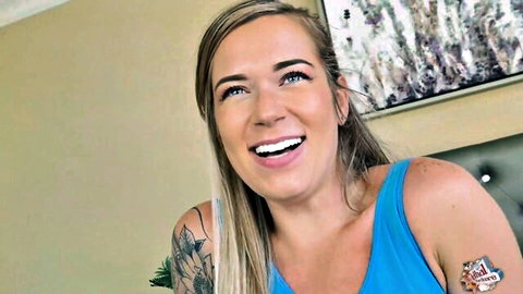 Rory Knox smiling in blue tank top with tattoos