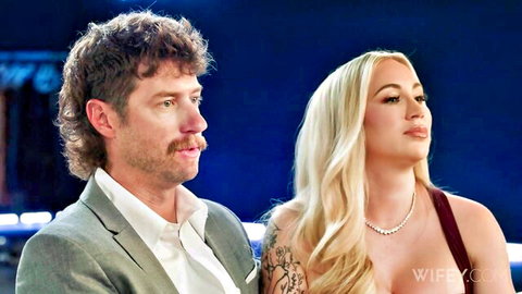 Jax Slayher with long-haired blonde wife in red dress, intimate couple pose