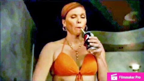Redhead woman in orange bikini sips Coke seductively