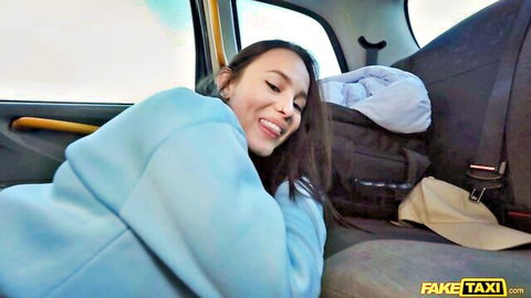 Smiling brunette in blue hoodie lounging seductively in Fake Taxi cab
