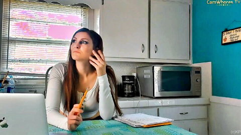 Curvy brunette amateur in tight white top teases with pencil to lips in kitchen webcam