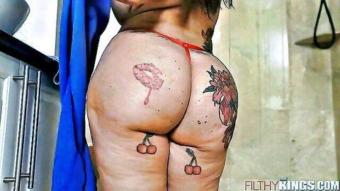 Tattooed big ass woman bends over in bathroom pulling red thong aside exposing pussy and asshole