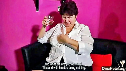Fat granny in open white blouse showing massive cleavage on couch