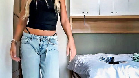 Blonde teen teases in black crop top and low-rise jeans exposing black thong in bedroom