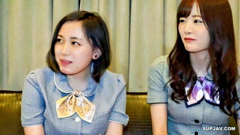 Two cute Asian women in school uniforms with bow ties posing seductively