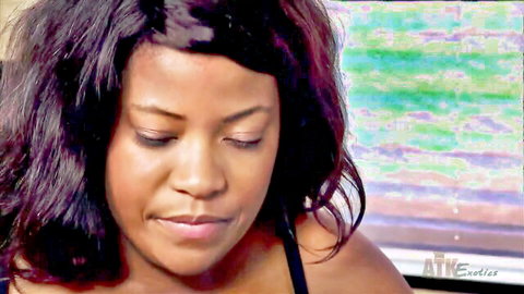 Exotic ebony Monique Symone close-up, busty in black top, teasing gaze