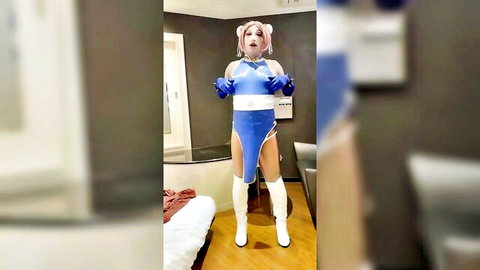 Pink-haired cosplay babe in shiny blue latex bodysuit and white thigh-high boots posing seductively