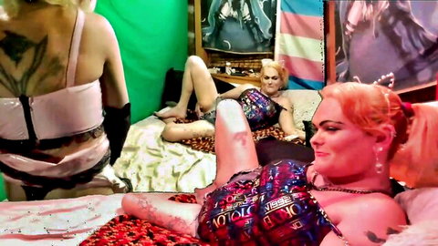 Tattooed blondes in lingerie lounging on bed, trans kink preview