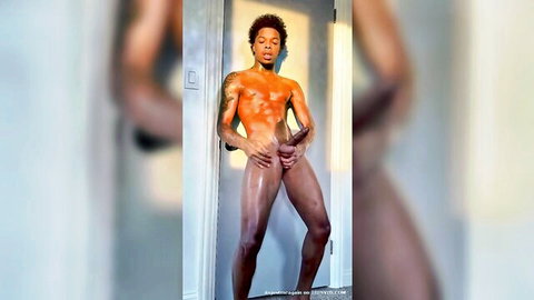 Muscular ebony young man posing nude with huge erection