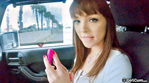 Petite brunette teen smiles holding pink vibrator in car POV