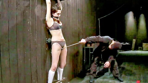 Bound brunette teen in lingerie has arms tied overhead while masked dom teases pussy with rod