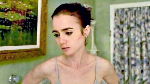 Brunette beauty in gray tank top gazes thoughtfully in green bedroom solo scene