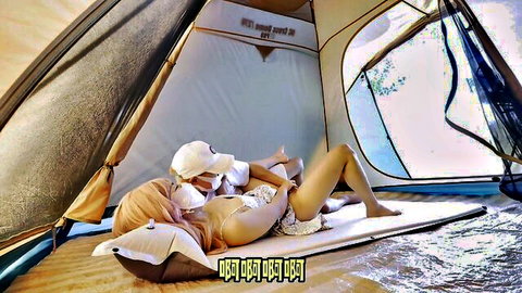 Amateur Asian woman in hat and mask lying topless with bare tits and white diaper in camping tent