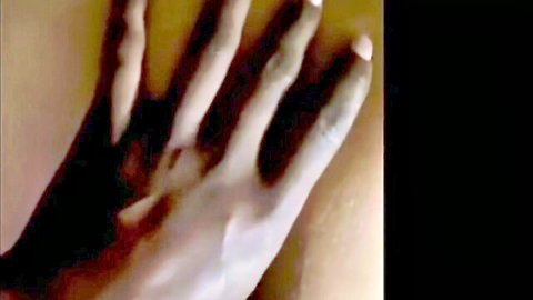 Closeup of manicured hand gripping thick veiny black cock during handjob.
