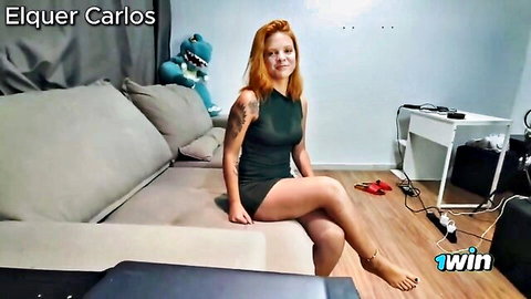 Raunchy Brazilian redhead babe in tight green dress posing on couch
