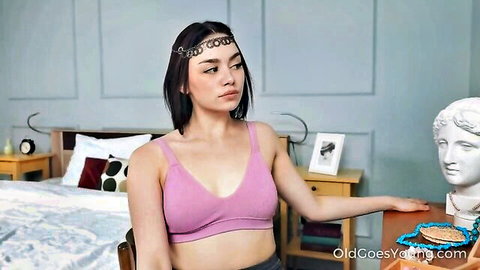Young Asian teen in tight pink tank top showing deep cleavage teasing in bedroom