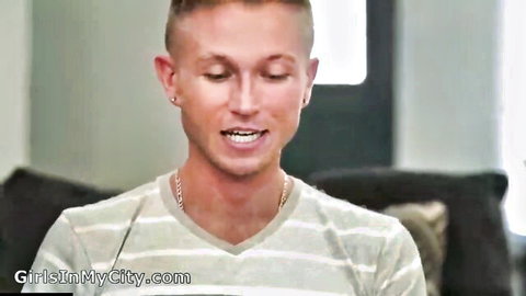 Handsome blonde guy smiling with earrings and gold chain in striped shirt