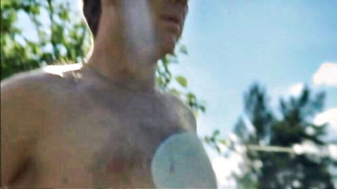 Shirtless man outdoors with chest patch in Maria Bonnevie Dragonflies scene