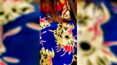 Cute girl in blue floral dress, long hair, teasing pose on bed