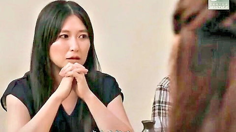 Two nervous Japanese women in casual tops, clasped hands in tense wife swap talk