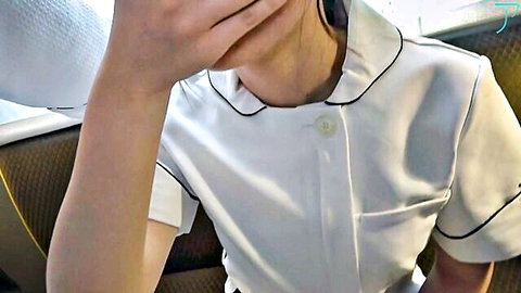 Cute Japanese nurse in tight white uniform wearing headphones on train seat