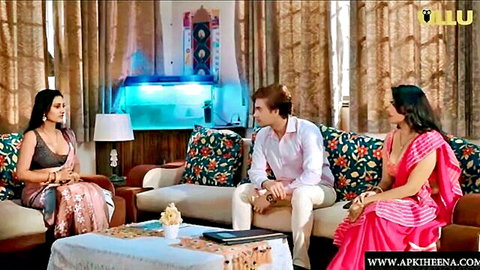 Two curvy Indian women in colorful sarees flirt with handsome man in living room