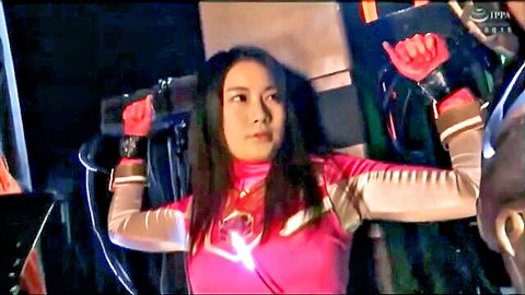 Asian woman in shiny pink cosplay suit posing with blaster gun