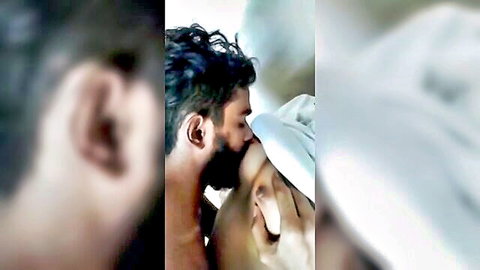 Blurry intimate kiss between bearded Indian man and woman in white cloth