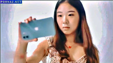 Sexy East Asian girl taking selfie in lacy top showing deep cleavage and tits