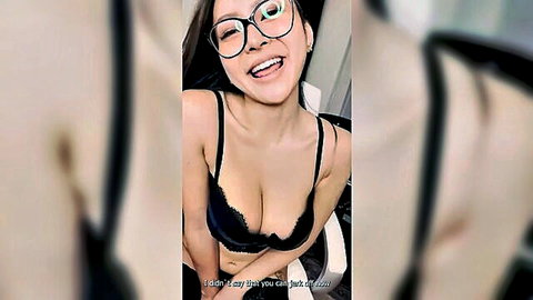 Hot Asian woman in black lace bra smiling with glasses, showing deep cleavage