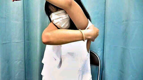 Masked Asian woman in off-shoulder white top, seductive pose