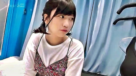 Cute Japanese girl with pigtails in floral bralette and tank top, shy gaze